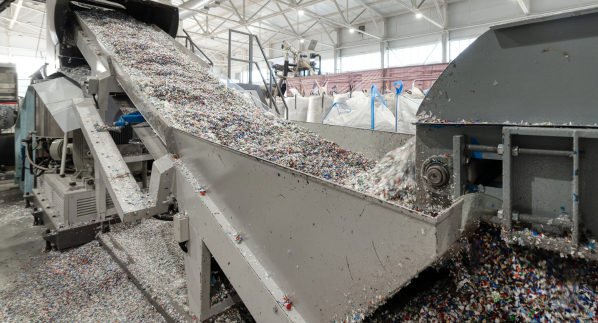 A recycling facility with machinery processing plastic waste, illustrating the industrial recycling process for plastic materials.